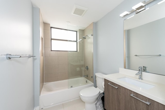 full bathroom with vanity, tiled shower / bath, toilet, and tile patterned flooring