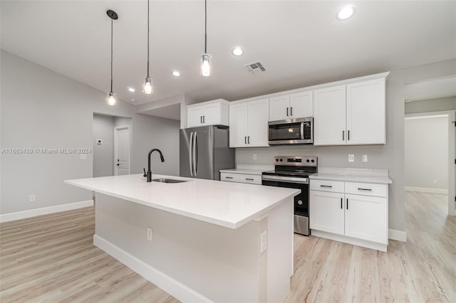 kitchen with a kitchen island with sink, sink, appliances with stainless steel finishes, and decorative light fixtures