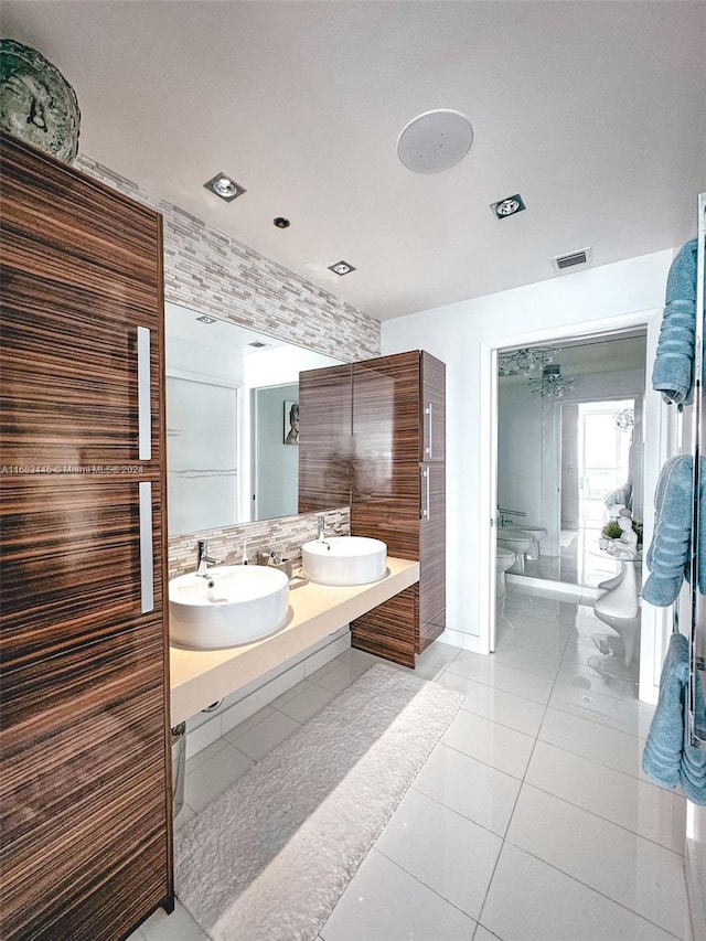 bathroom with toilet, vanity, and tile patterned floors