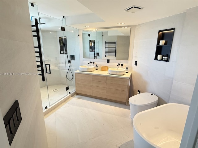 full bathroom featuring vanity, separate shower and tub, toilet, and tile walls