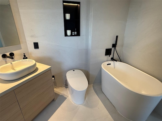 bathroom with a tub, tile patterned flooring, toilet, vanity, and tile walls