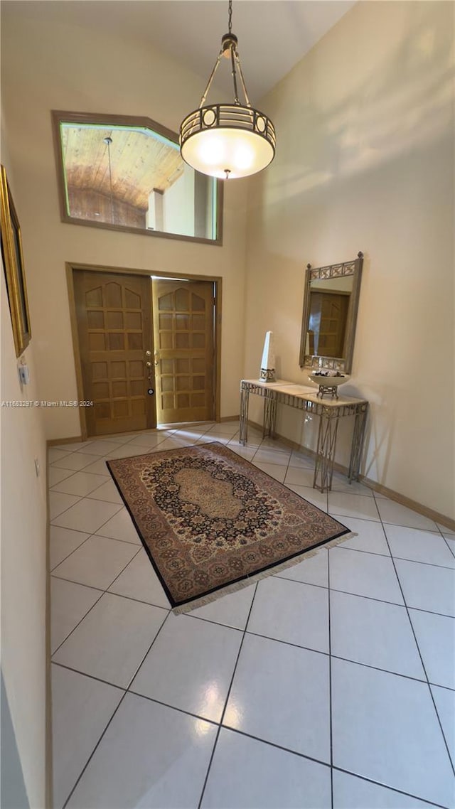 tiled foyer entrance featuring high vaulted ceiling