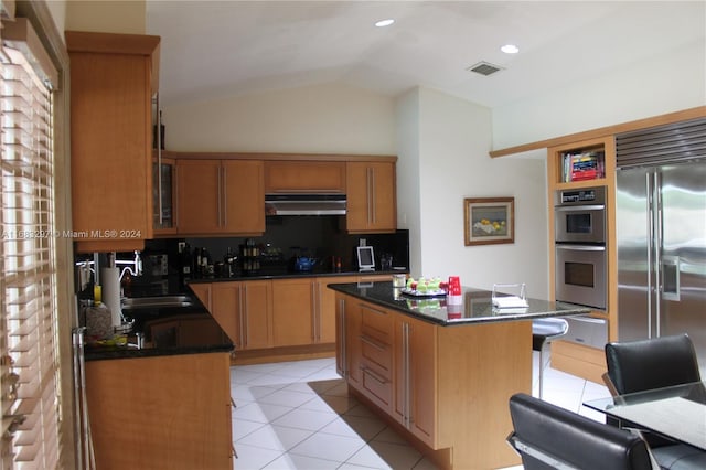 kitchen featuring tasteful backsplash, sink, a kitchen island, stainless steel appliances, and lofted ceiling