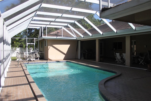 view of swimming pool with a patio area and glass enclosure