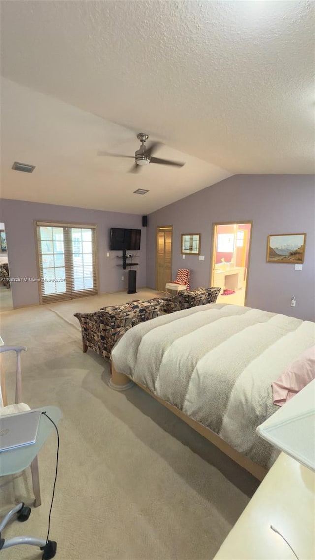 bedroom with ceiling fan, a textured ceiling, carpet flooring, and lofted ceiling