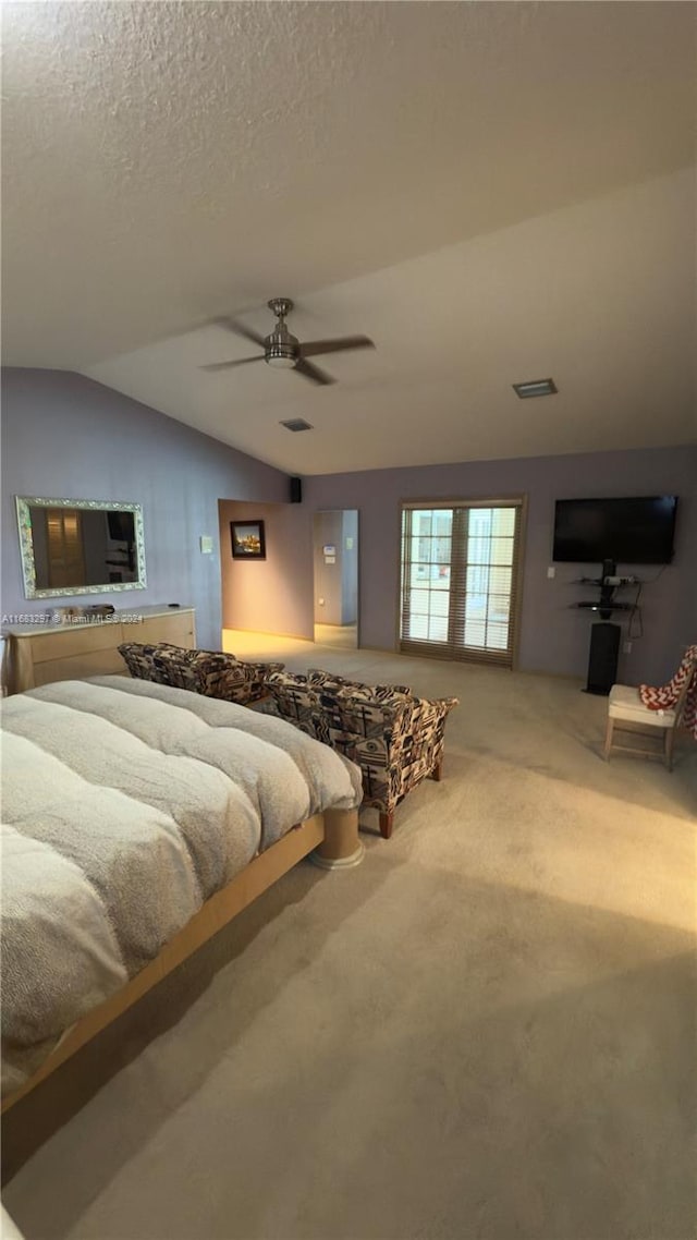 carpeted bedroom featuring ceiling fan, a textured ceiling, and lofted ceiling