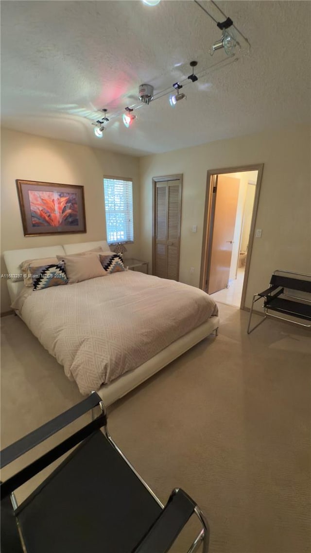 carpeted bedroom with a textured ceiling and a closet