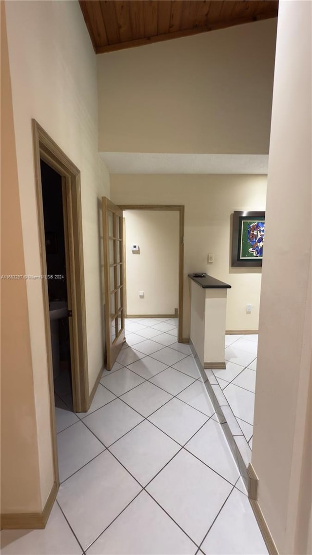 hallway featuring wood ceiling and light tile patterned floors