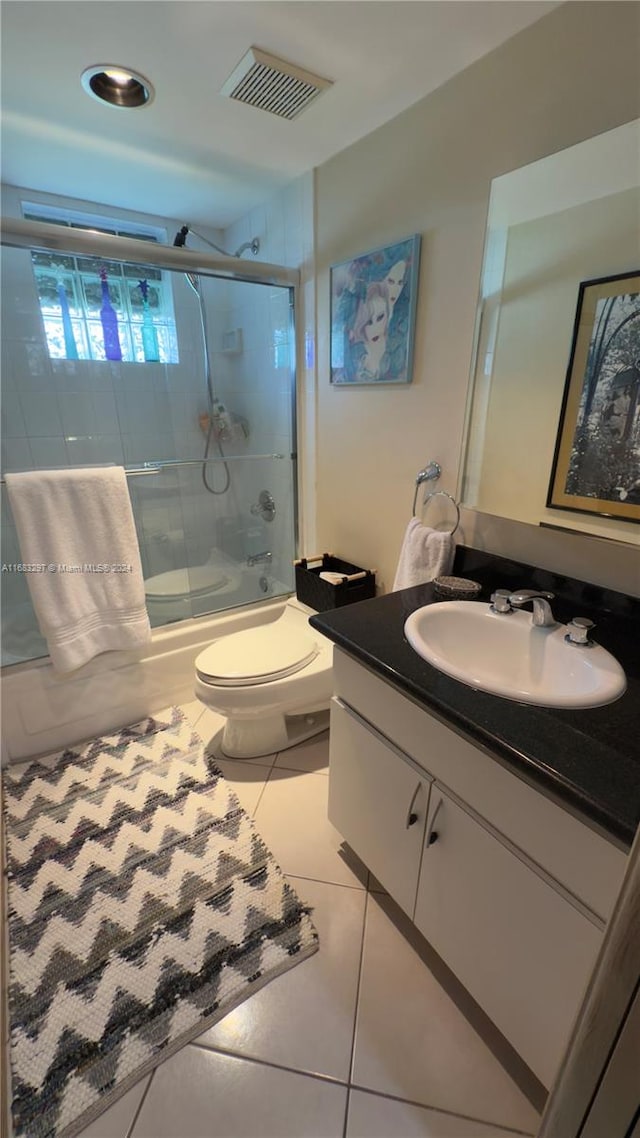 full bathroom with vanity, toilet, enclosed tub / shower combo, and tile patterned flooring