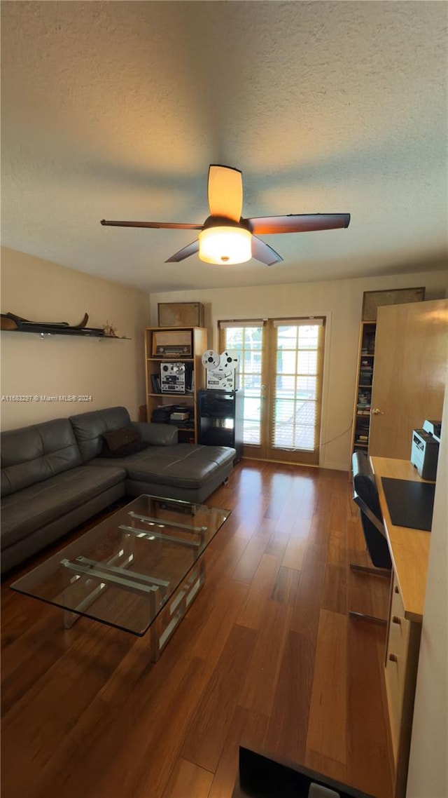 living room with a textured ceiling, hardwood / wood-style flooring, and ceiling fan