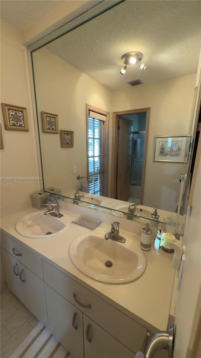 bathroom featuring vanity, a textured ceiling, and tile patterned floors