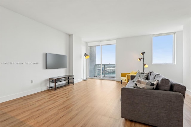 living room featuring a wall of windows and light wood-type flooring