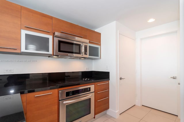 kitchen featuring stainless steel appliances and light tile patterned flooring