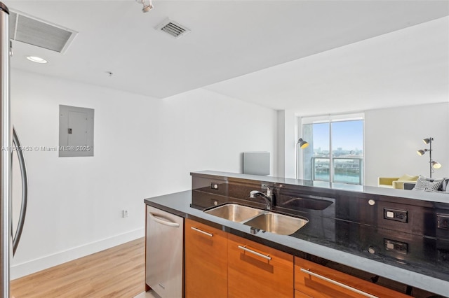 kitchen with sink, dishwasher, electric panel, and light wood-type flooring