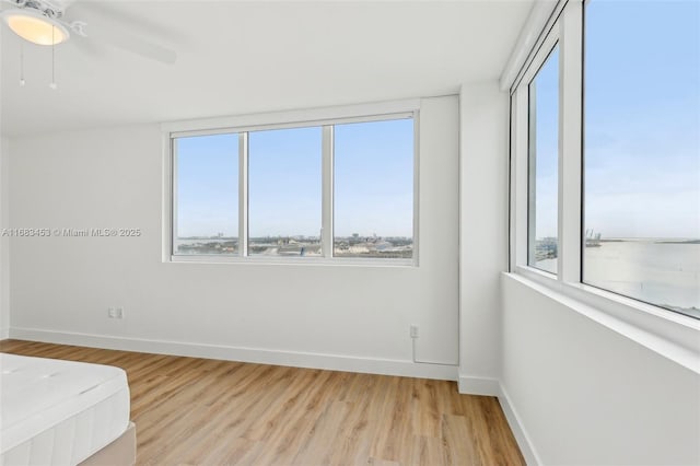 unfurnished bedroom featuring multiple windows, ceiling fan, and light hardwood / wood-style floors