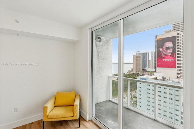 living area with wood-type flooring, a wealth of natural light, and floor to ceiling windows