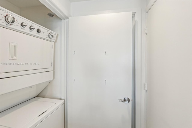 clothes washing area featuring stacked washer and clothes dryer