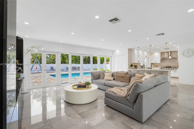 living area featuring recessed lighting, visible vents, and french doors