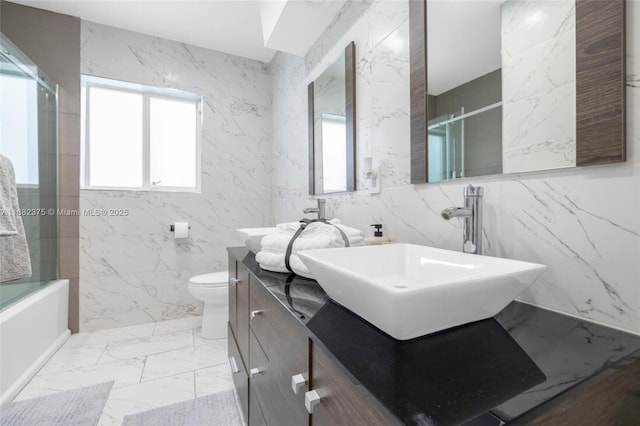 full bath with stone wall, marble finish floor, vanity, and toilet