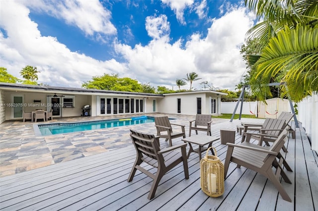 wooden terrace featuring fence, a fenced in pool, and area for grilling