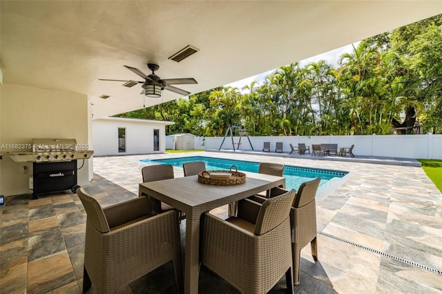 view of swimming pool with a ceiling fan, a fenced in pool, a fenced backyard, a patio area, and outdoor dining space