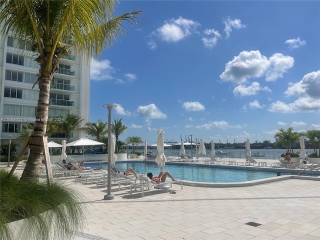 view of pool with a patio and a water view