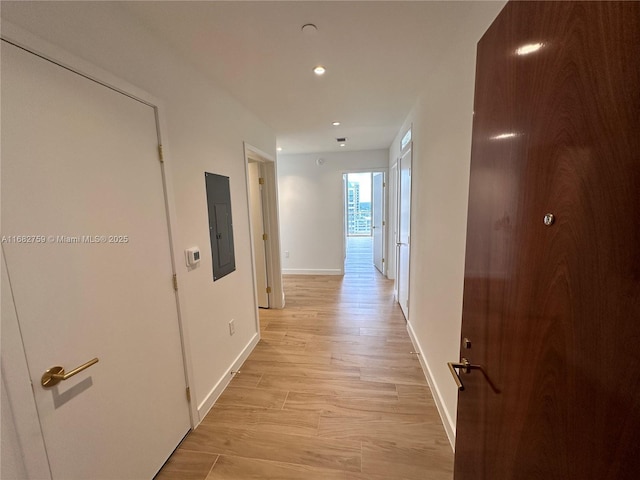 hallway featuring electric panel and light hardwood / wood-style floors