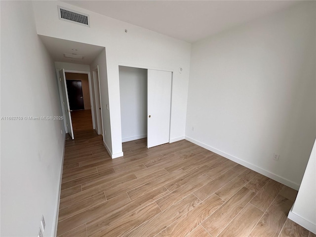 unfurnished bedroom with light hardwood / wood-style floors and a closet