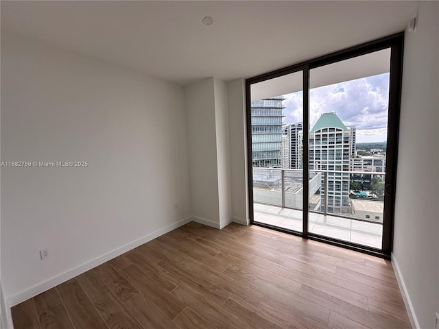 empty room featuring hardwood / wood-style floors and a wall of windows