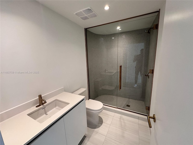 bathroom featuring vanity, toilet, tile patterned flooring, and a shower with door