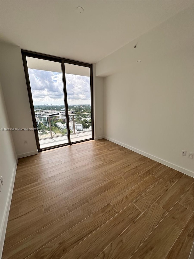 spare room featuring wood-type flooring and floor to ceiling windows