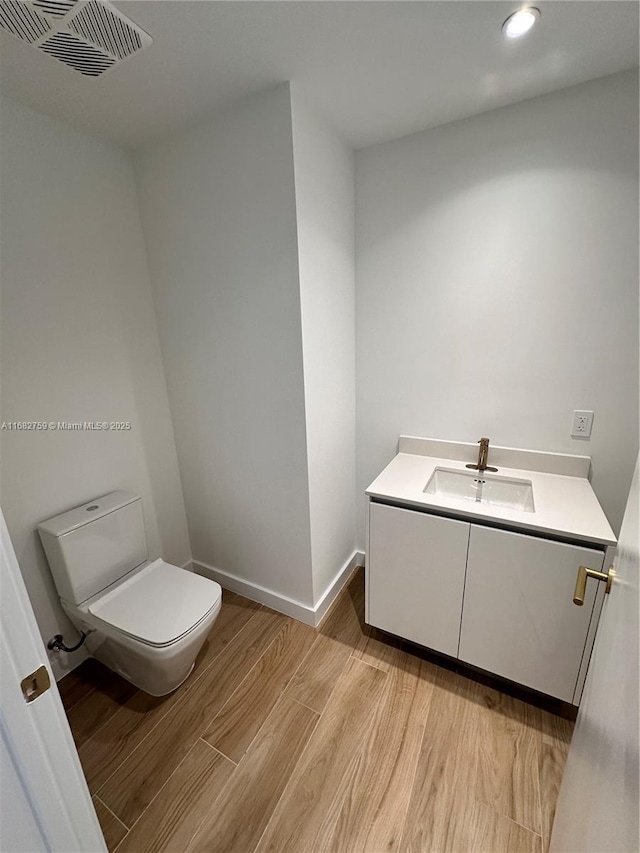 bathroom featuring hardwood / wood-style flooring, vanity, and toilet