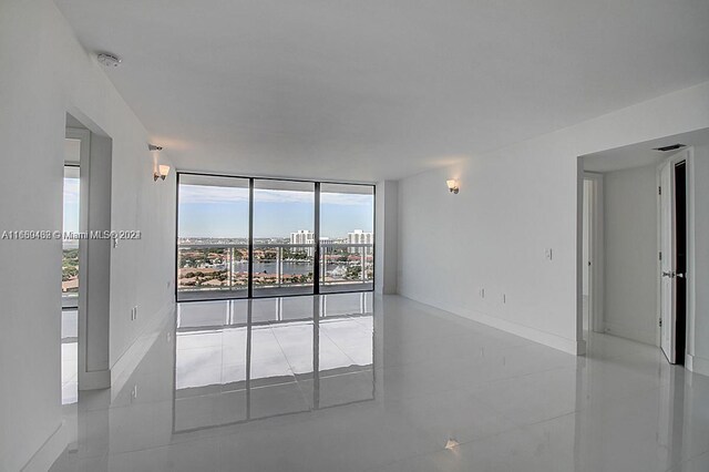 20505 E Country Club Dr Unit 1931, Aventura, FL 33180 - spare room with tile patterned floors, a smoke detector, a wall of windows, and a city view
