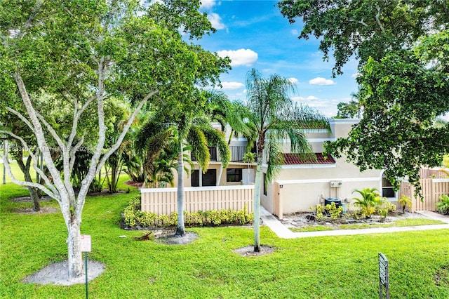 view of front of property with a balcony and a front lawn