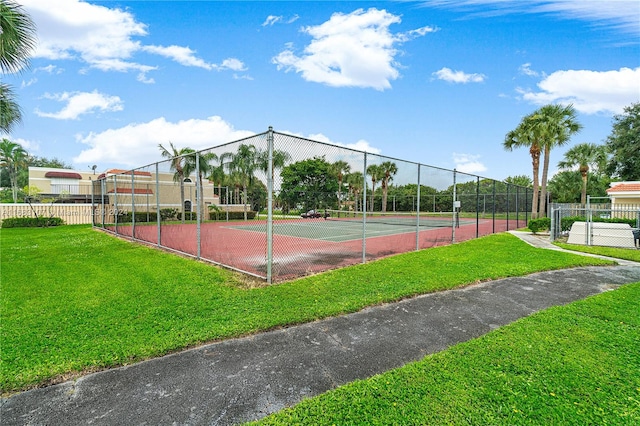 view of tennis court featuring a yard