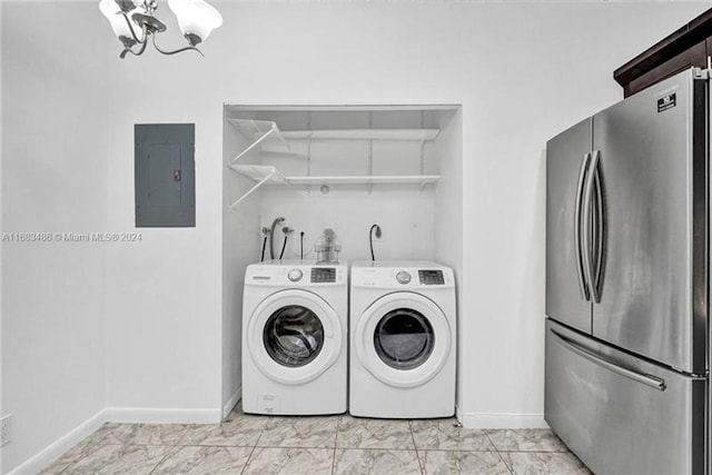 clothes washing area with electric panel, a chandelier, and washer and dryer