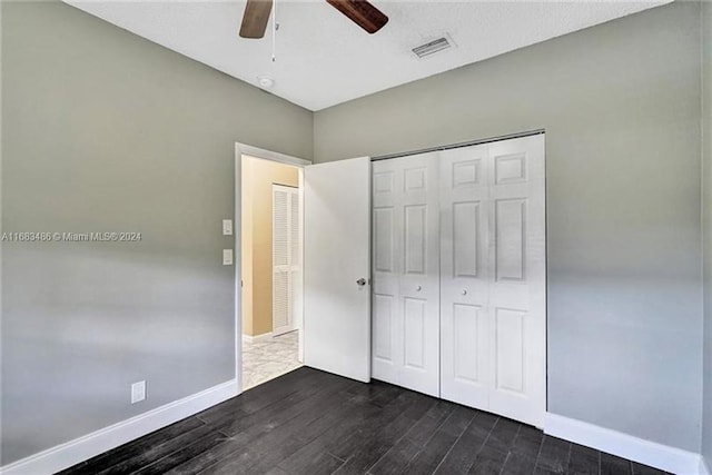 unfurnished bedroom featuring ceiling fan, dark hardwood / wood-style flooring, and a closet