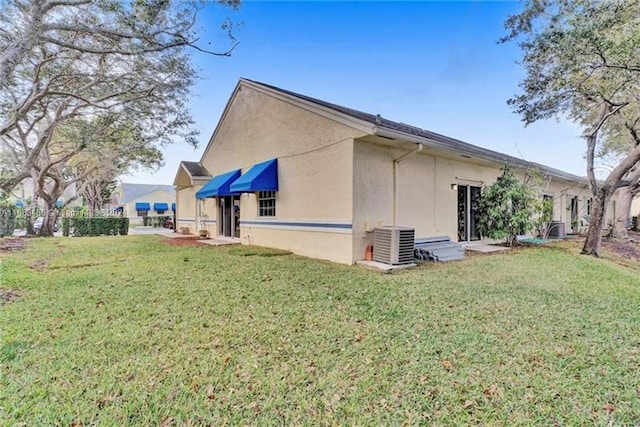 view of property exterior with a lawn and central AC unit