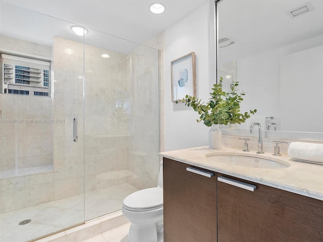 bathroom with vanity, a shower with shower door, toilet, and tile patterned floors