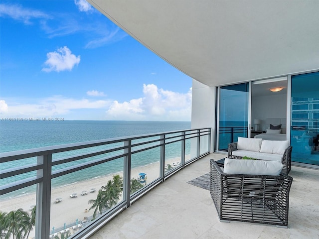 balcony featuring a view of the beach and a water view