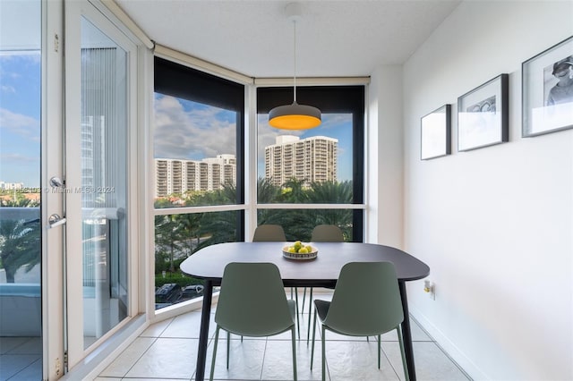 dining area featuring light tile patterned floors and a wall of windows