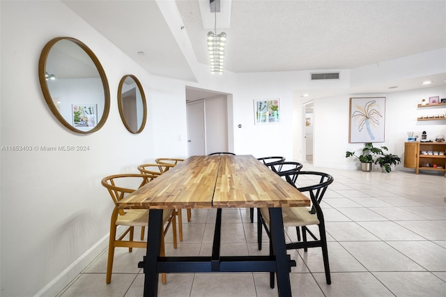 tiled dining room with a textured ceiling