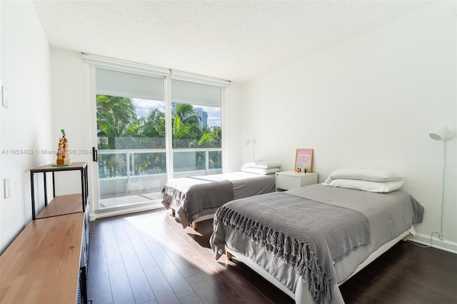 bedroom with dark wood-type flooring and a textured ceiling