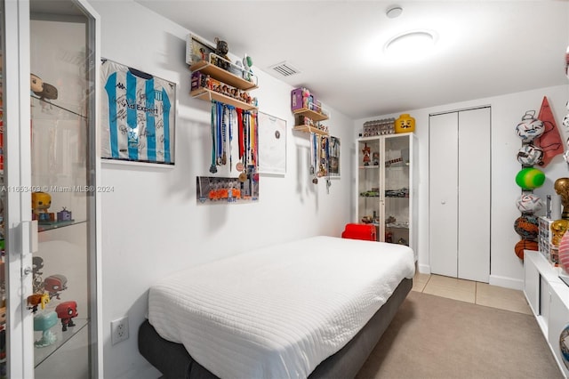 bedroom with light carpet and a closet