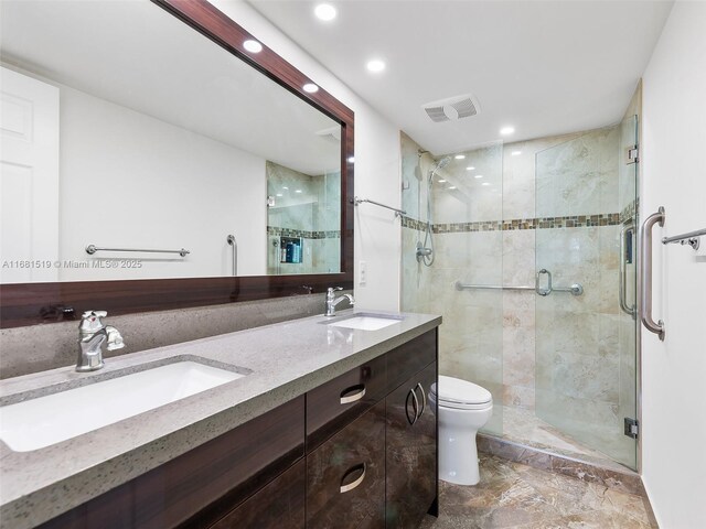 bathroom with vanity, toilet, and a shower with shower door