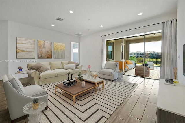 living room featuring light hardwood / wood-style floors and a textured ceiling