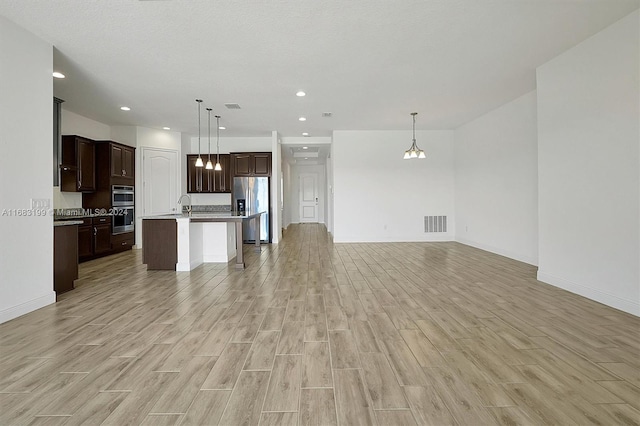 unfurnished living room featuring sink and light hardwood / wood-style floors