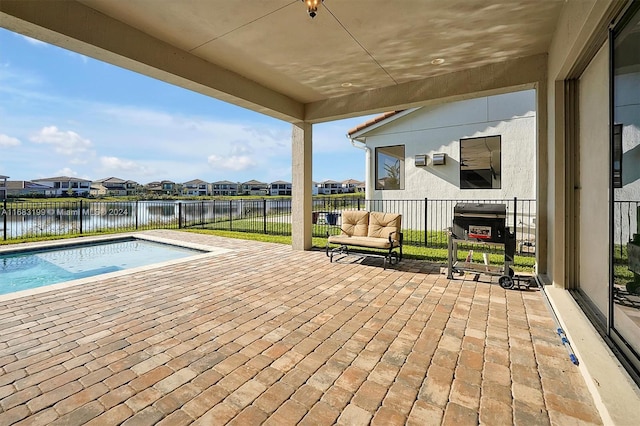 view of swimming pool featuring a water view and a patio area