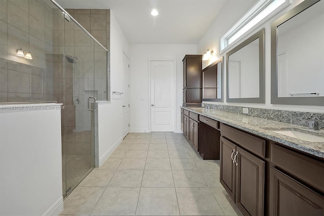 bathroom featuring a shower with door, vanity, and tile patterned floors