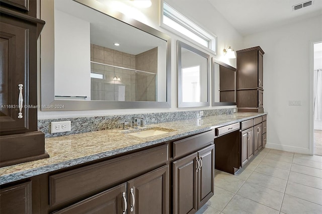 bathroom featuring a shower with door, vanity, and tile patterned flooring